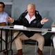 U.S. President Donald Trump sits between Puerto Rico Governor Ricardo Rossello and first lady Melania Trump, as he receives a briefing on hurricane damage at Muniz Air National Guard Base.
